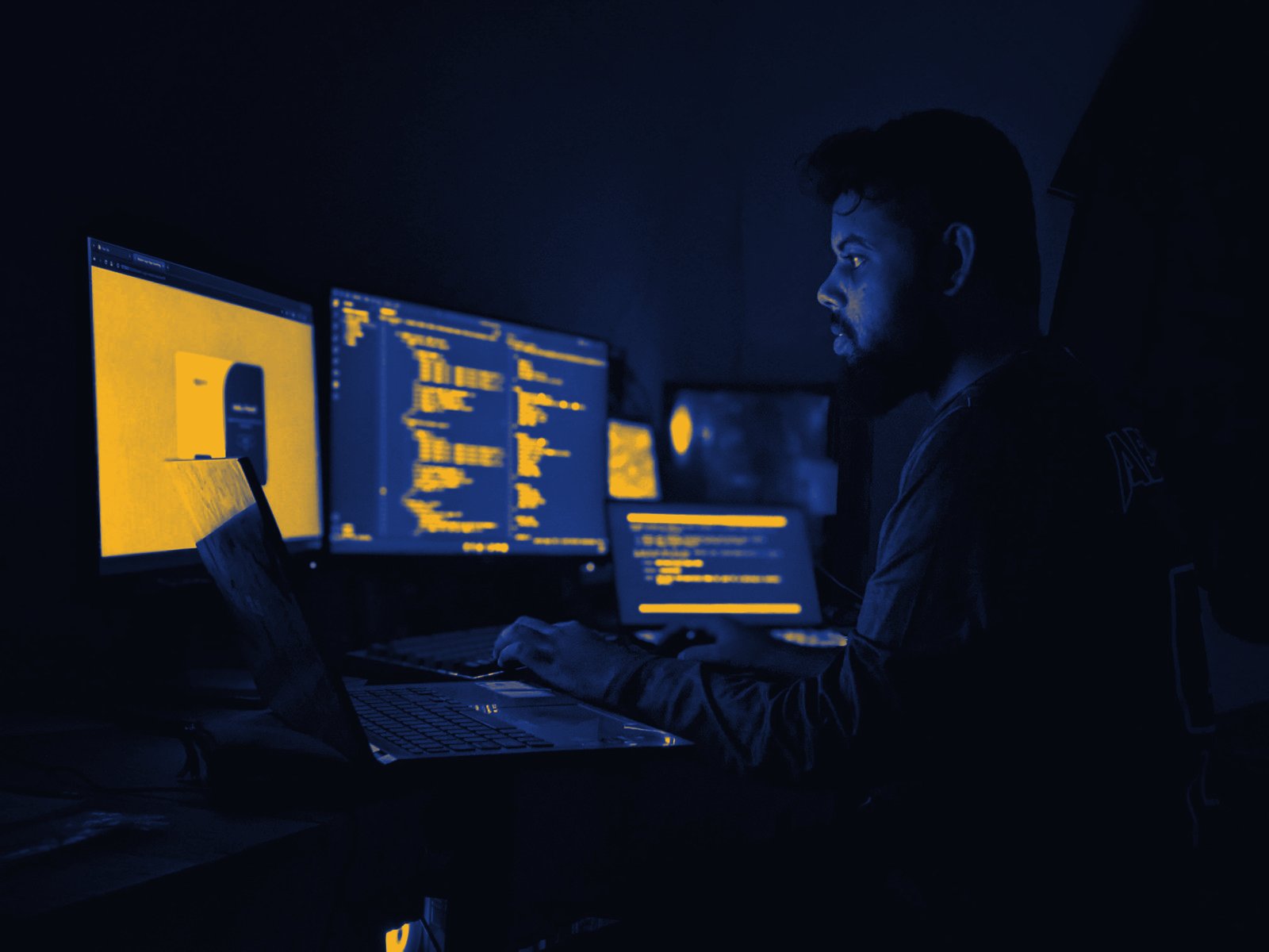 A researcher working through data at a desk with several screens